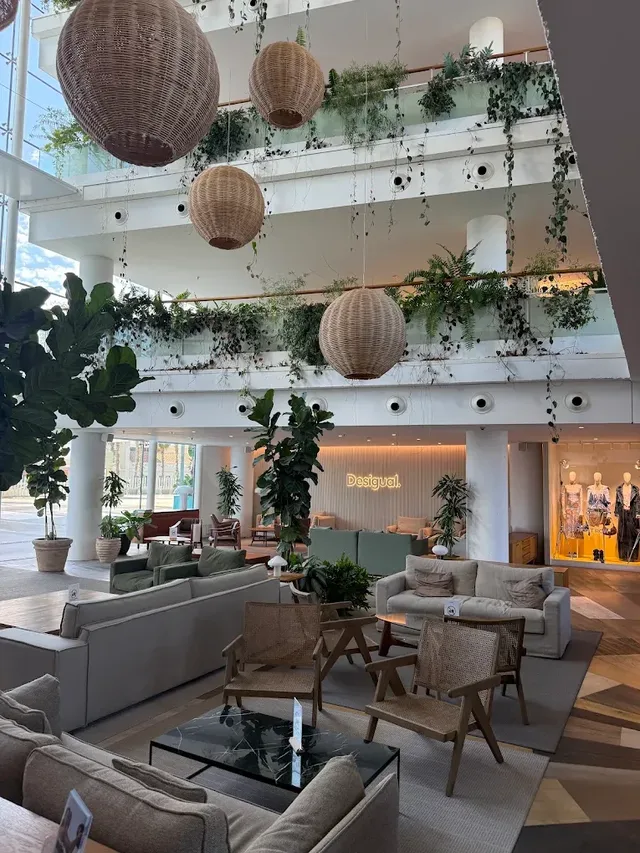 The atrium at Norrsken House, hanging lamps and plants over the seating